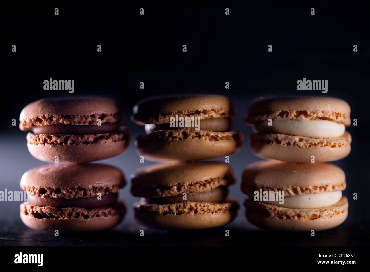 amaretti di cioccolato, caffè, vaniglia, limone e fragola su sfondo nero Foto Stock