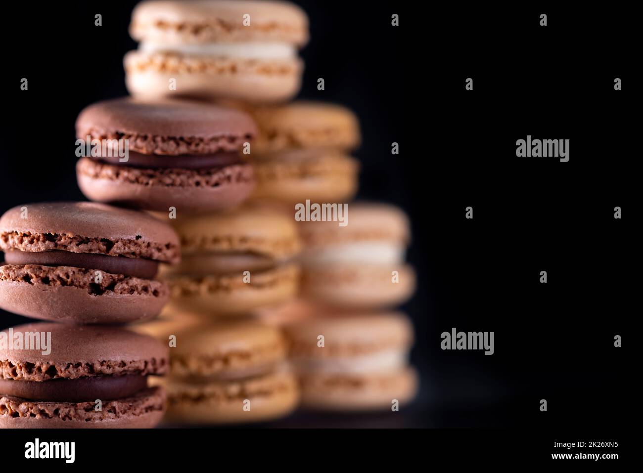 amaretti di cioccolato, caffè, vaniglia, limone e fragola su sfondo nero Foto Stock