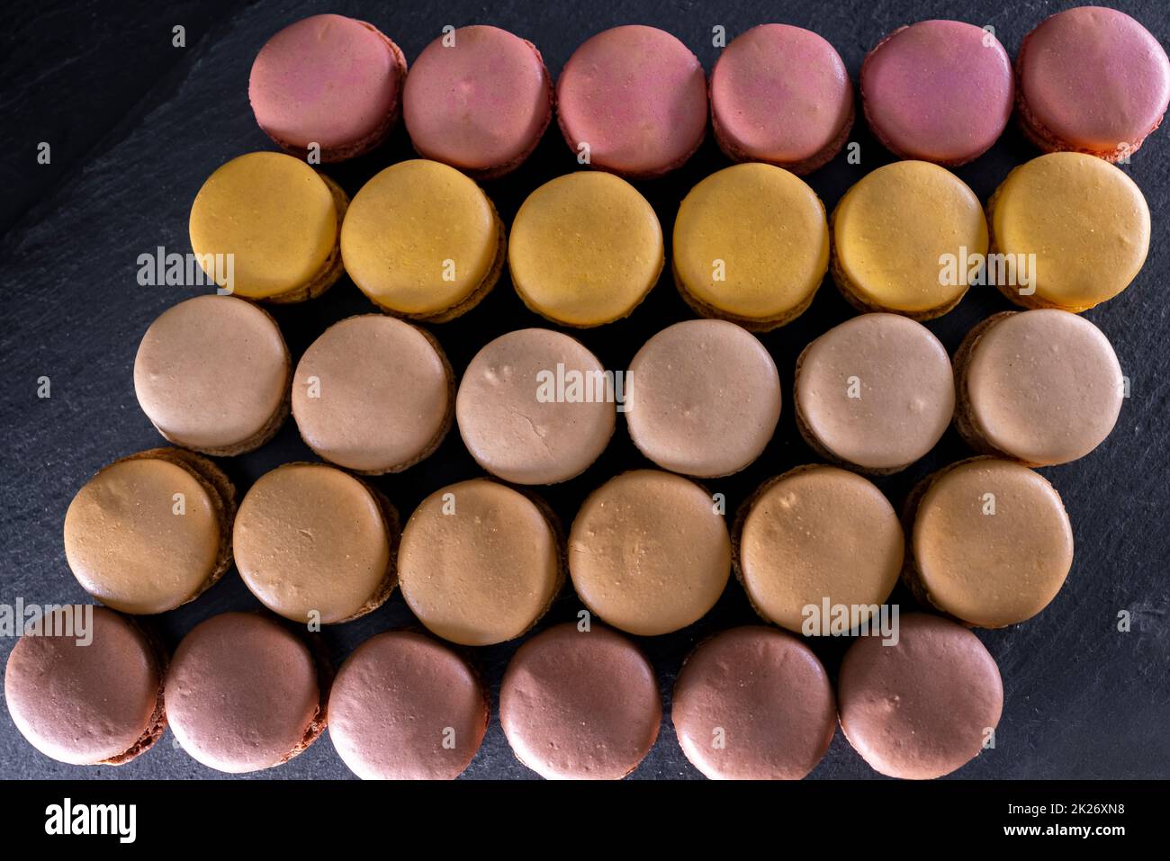 amaretti di cioccolato, caffè, vaniglia, limone e fragola su sfondo nero Foto Stock