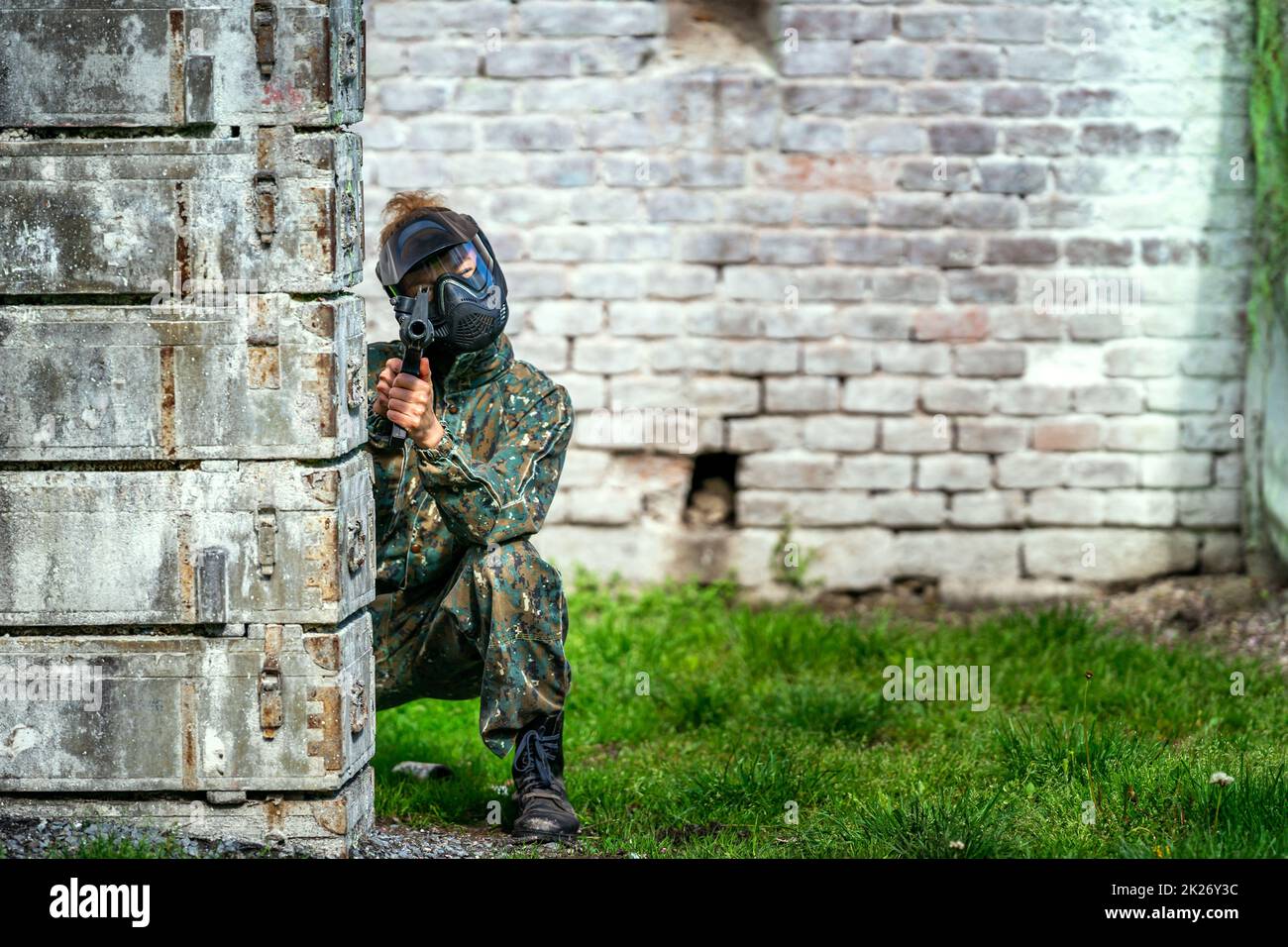 giovane donna in azione mentre si gioca paintball Foto Stock