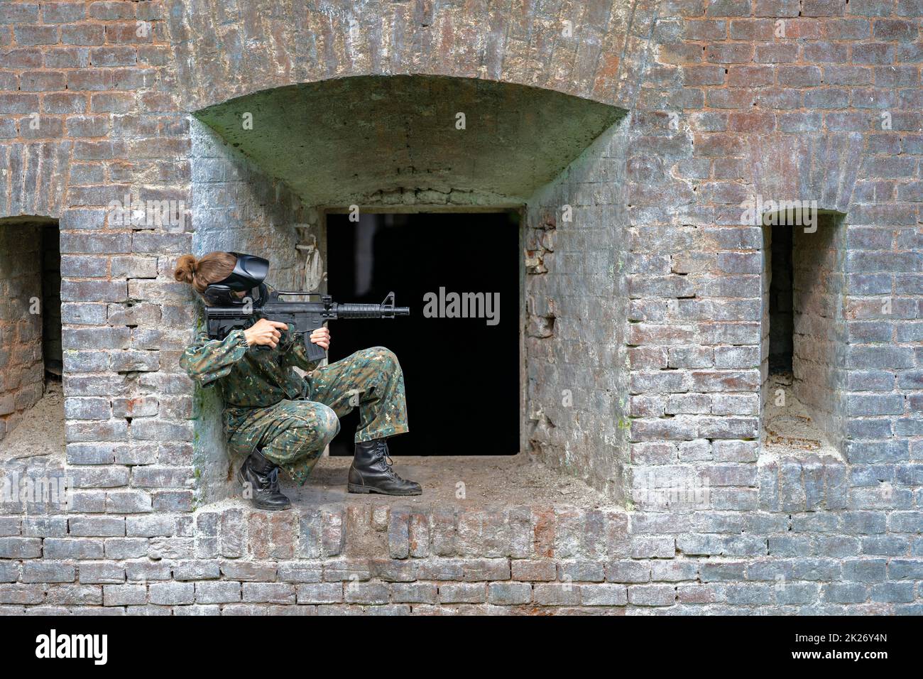 donna in uniforme con una pistola in allenamento militare paintball Foto Stock