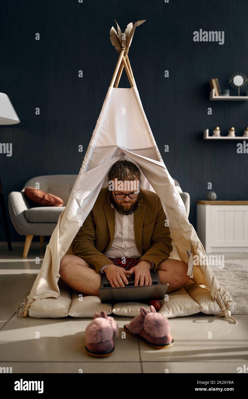 Felice uomo d'affari che lavora un laptop in tenda di casa Foto Stock