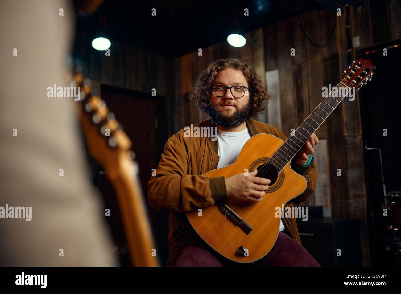 Tutor di musica che spiega le caratteristiche di suonare la chitarra Foto Stock