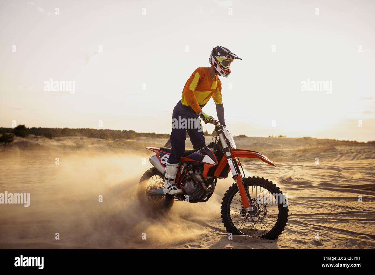 Pilota di motocross su motore sportivo su paesaggio polveroso Foto Stock
