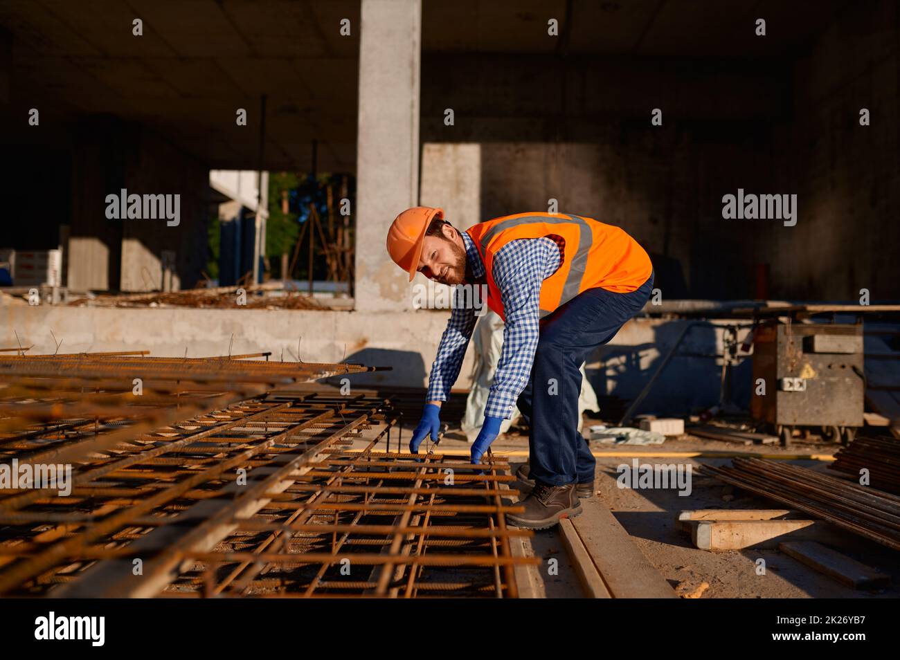 Lavoratore di costruzione che prende armatura di rinforzo della griglia metallica Foto Stock