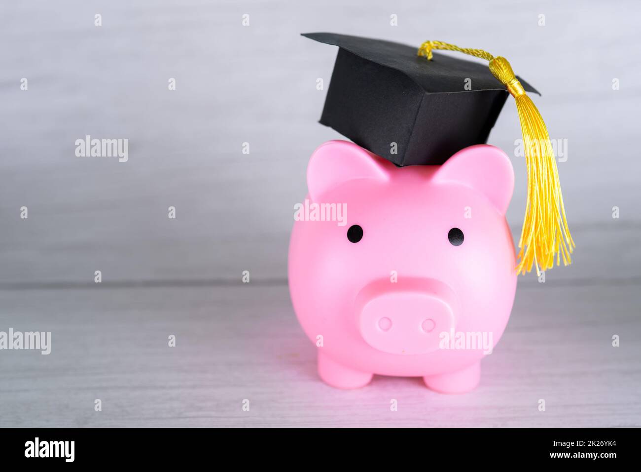 Piggy banca con tappo di graduazione, Business finance formazione risparmio denaro concetto di borsa di studio. Foto Stock