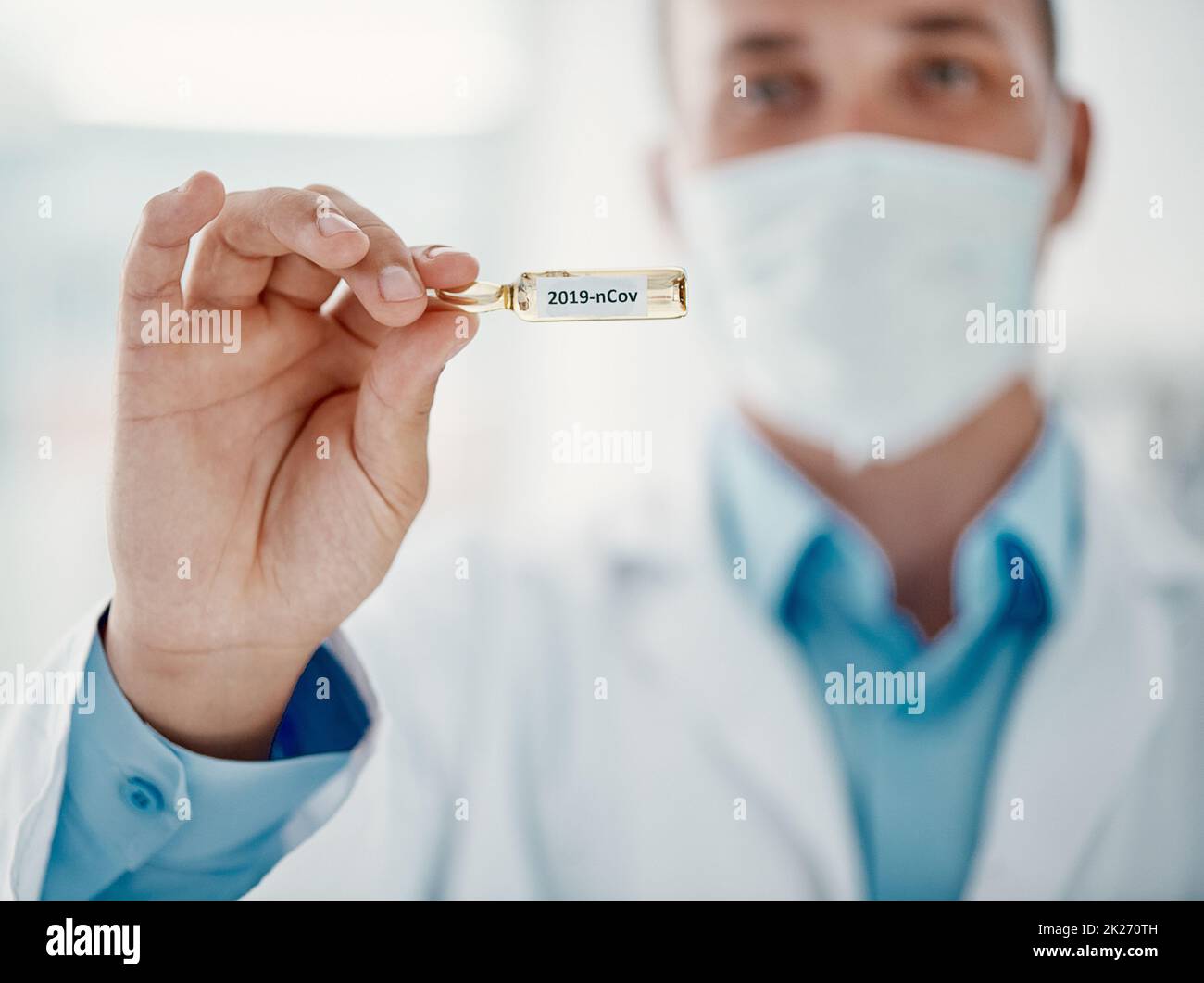 Preparati a guarire. Scatto corto di uno scienziato che tiene una fiala con 2019-nCov su di esso. Foto Stock