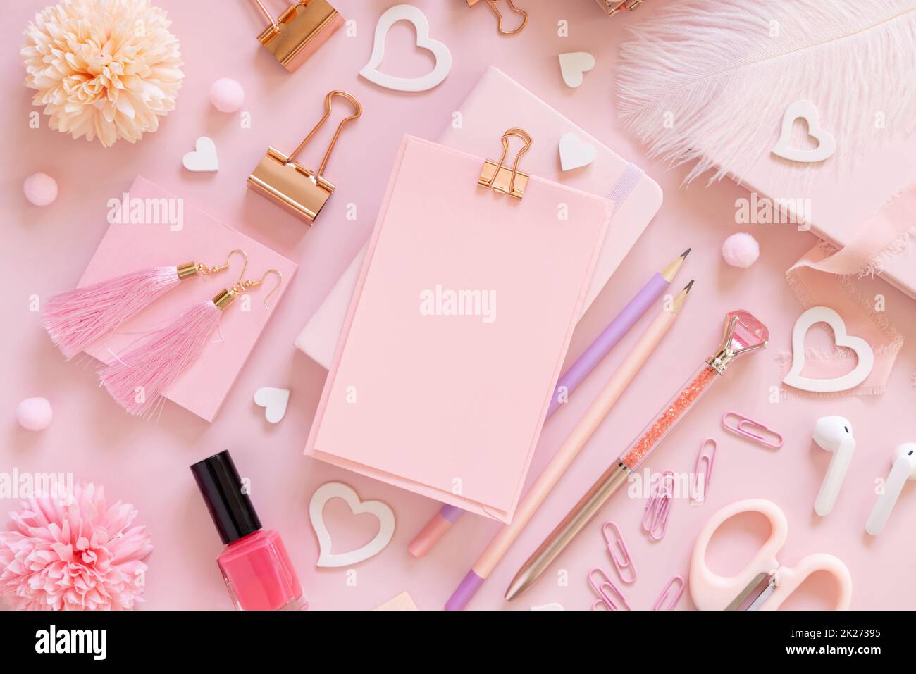 Cartoncino rosa con clip, accessori per la scuola e cuori sulla vista dall'alto rosa pastello, mockup Foto Stock