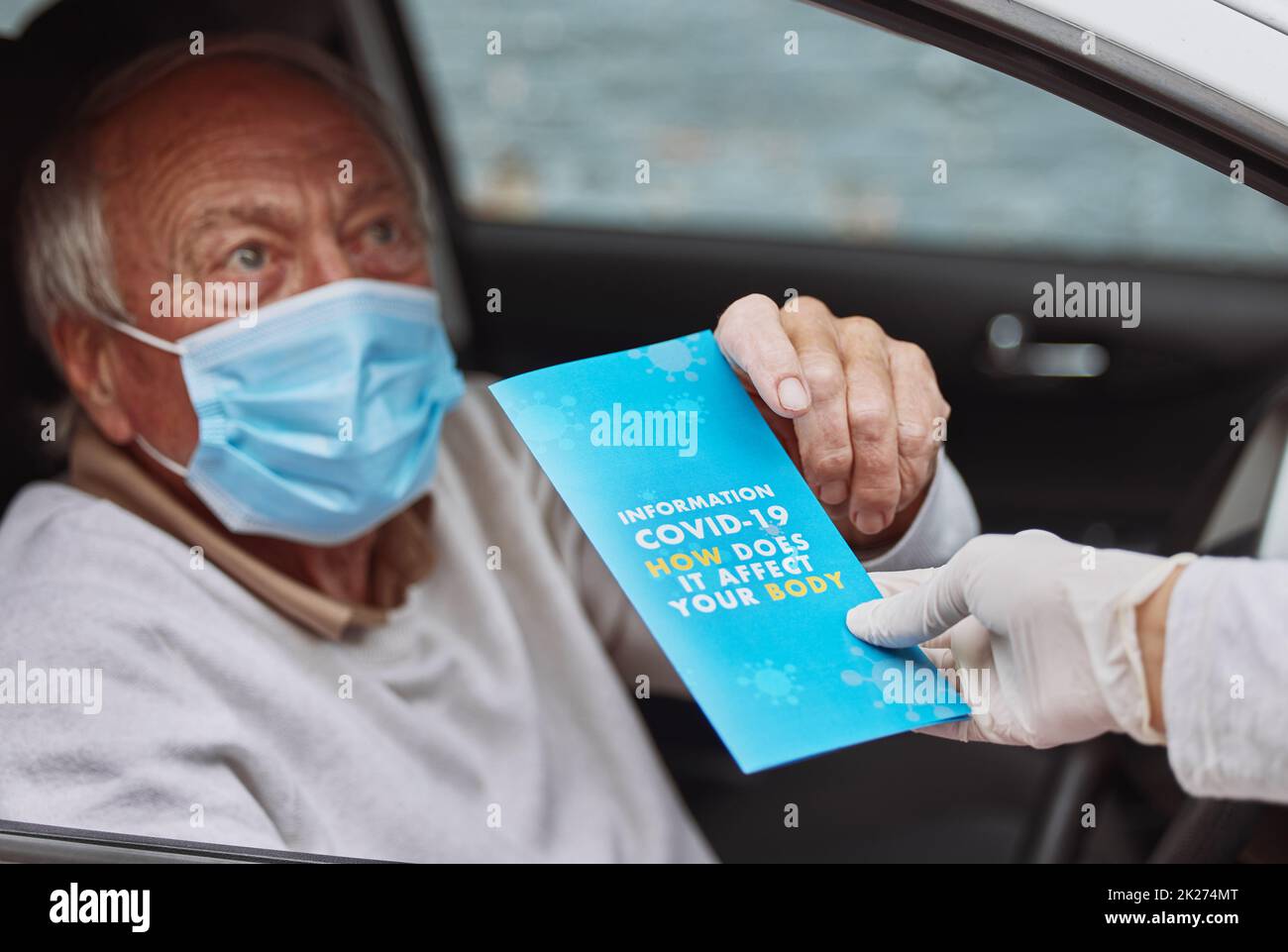 Rimani informato sul virus del covid. Shot di un uomo anziano che prende un opuscolo da un operatore sanitario in un viaggio attraverso il sito di vaccinazione. Foto Stock