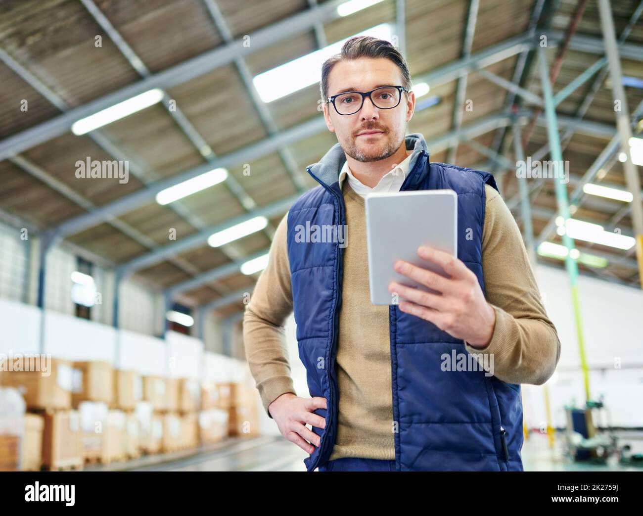 Monitoraggio e tracciamento dell'ordine. Ritratto di un uomo con un tablet digitale che lavora in un magazzino di distribuzione. Foto Stock