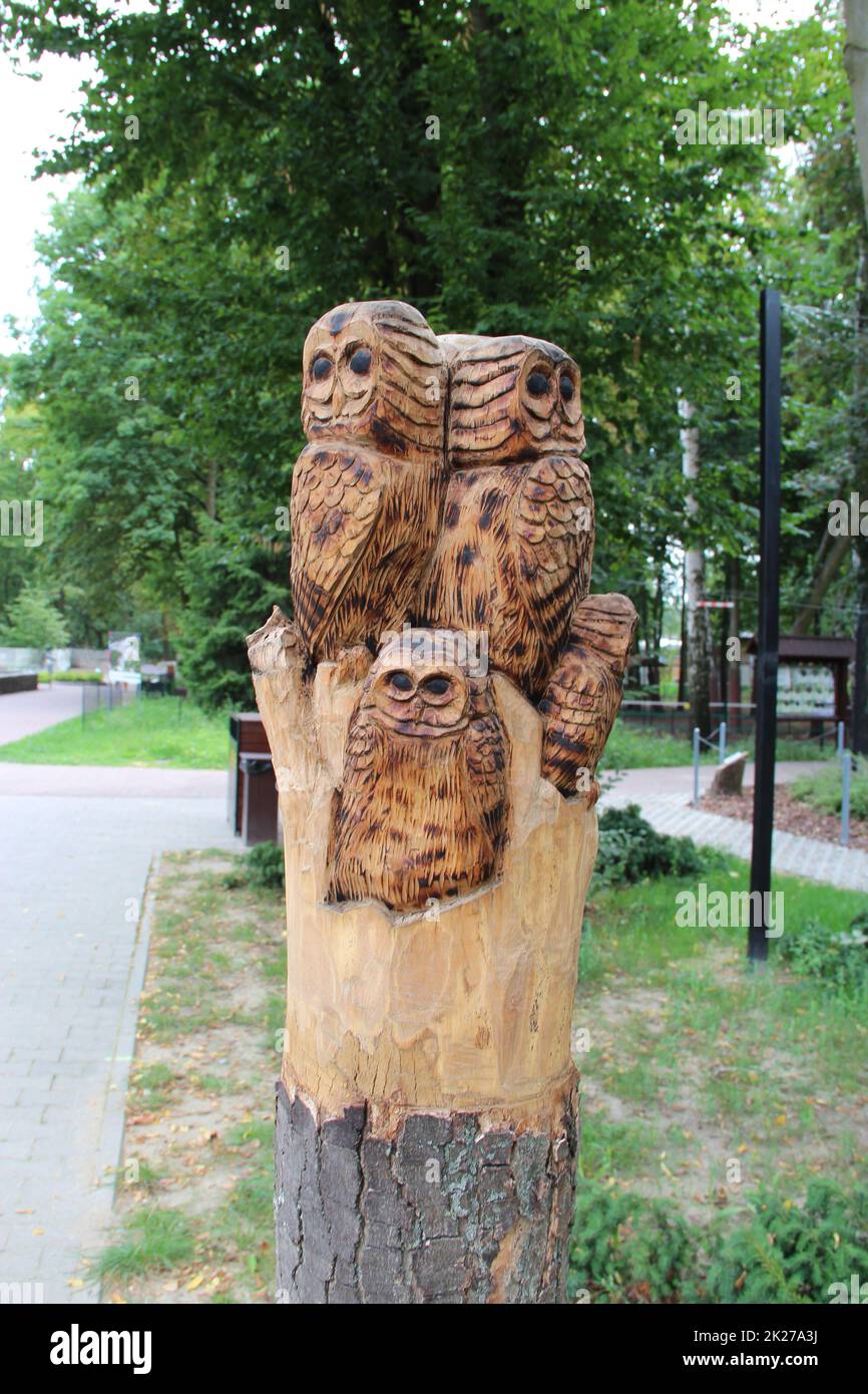 figura fatta di legno, famiglia di gufi. Scultura in legno fatta a mano. Gufi di legno Foto Stock