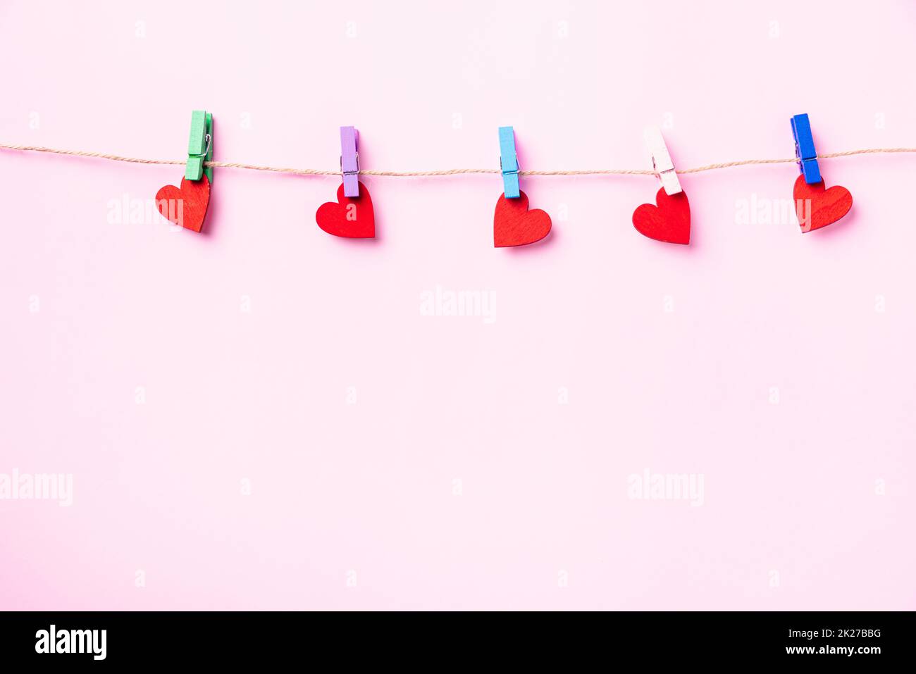 decorazione a valentine a forma di cuore rosso appeso con clip in legno Foto Stock