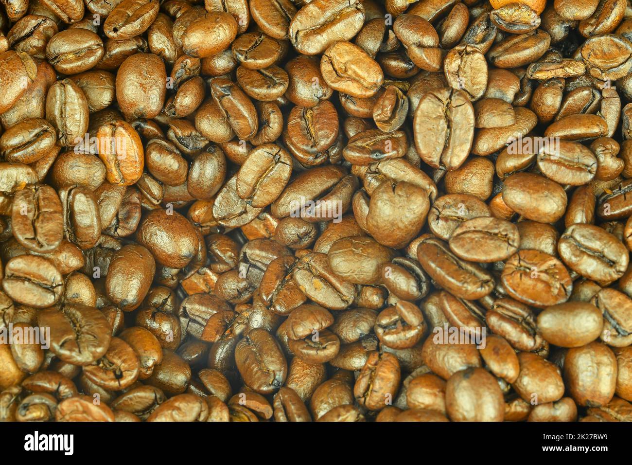 Macrofone di chicchi di caffè tostati. Struttura naturale. Grana di fondo caffè arrosto. Caffè arabo arrosto - ingrediente della bevanda calda. Chicchi di caffè marroni per lo sfondo e la consistenza Foto Stock