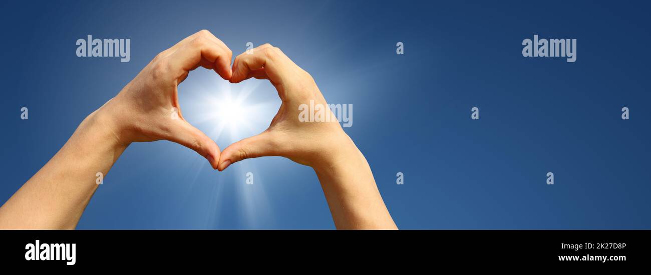 Cuore a forma di mano contro il tramonto. Concetto di giorno di San Valentino Foto Stock