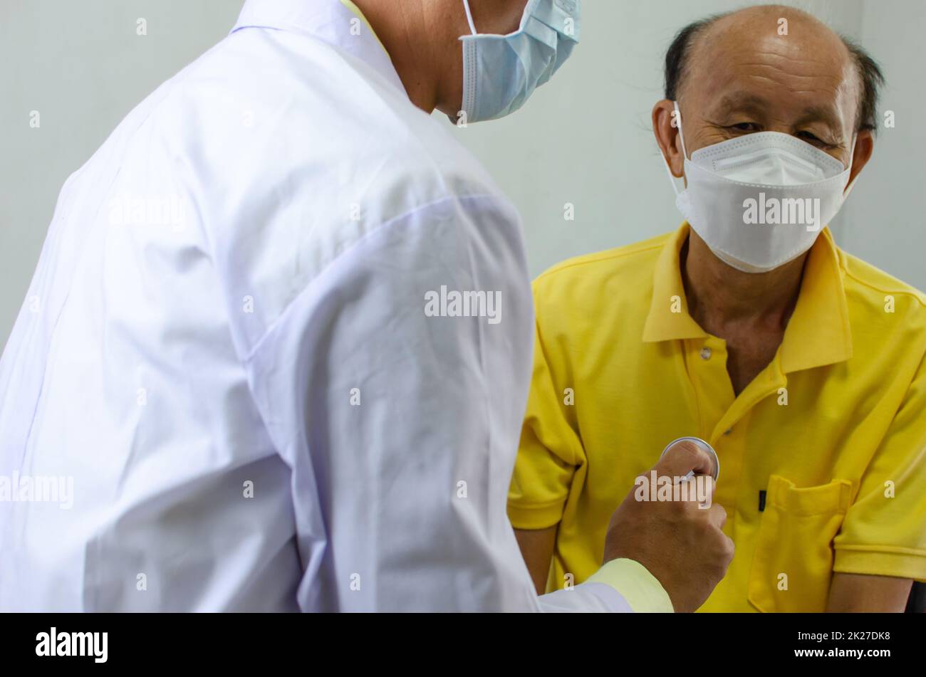 il medico controlla il battito cardiaco di un uomo anziano Foto Stock
