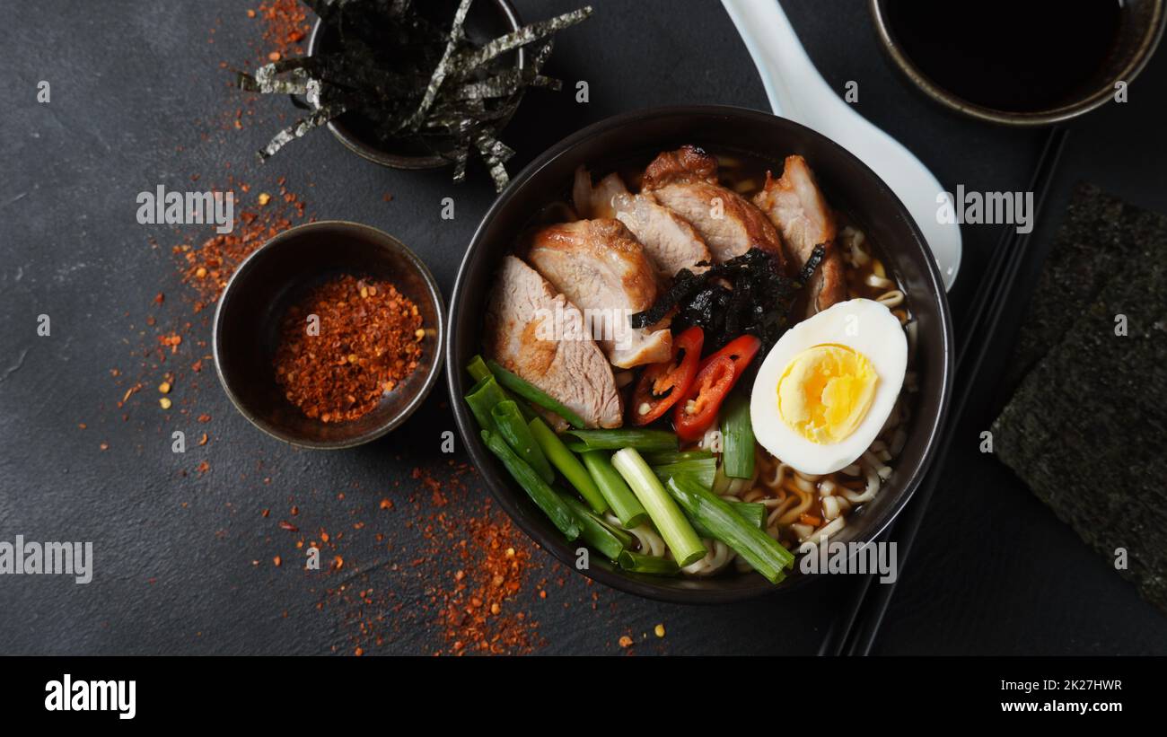 Zuppa di ramen con uova sode, verdure, maiale, salsa di soia. Tonkotsu ramen giapponese, spaghetti di brodo di ossa di maiale Foto Stock