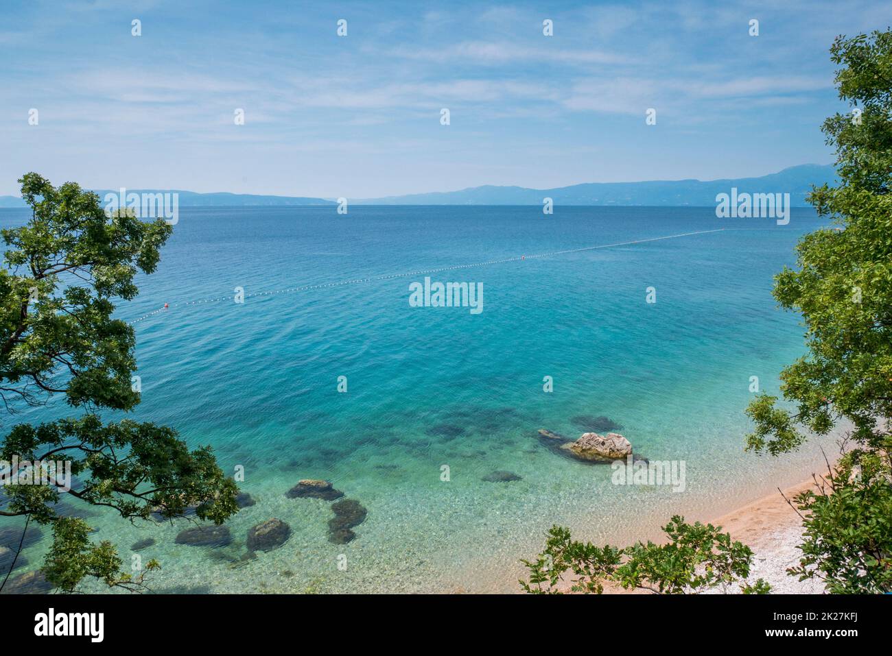 Mare, spiaggia e alberi verdi a Kostrena, Croazia Foto Stock