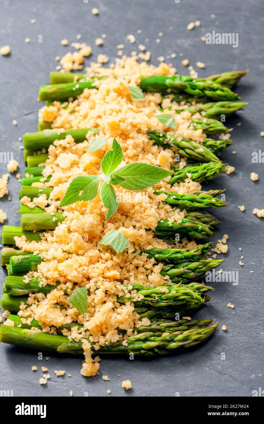 parmigiano e pangrattato su asparagi verdi Foto Stock