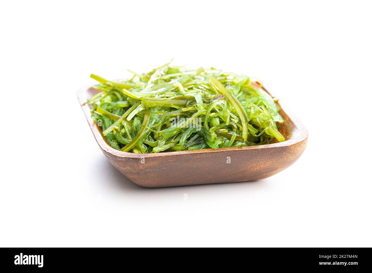 Wakame verde. Insalata di alghe in ciotola di legno isolata su sfondo bianco. Foto Stock