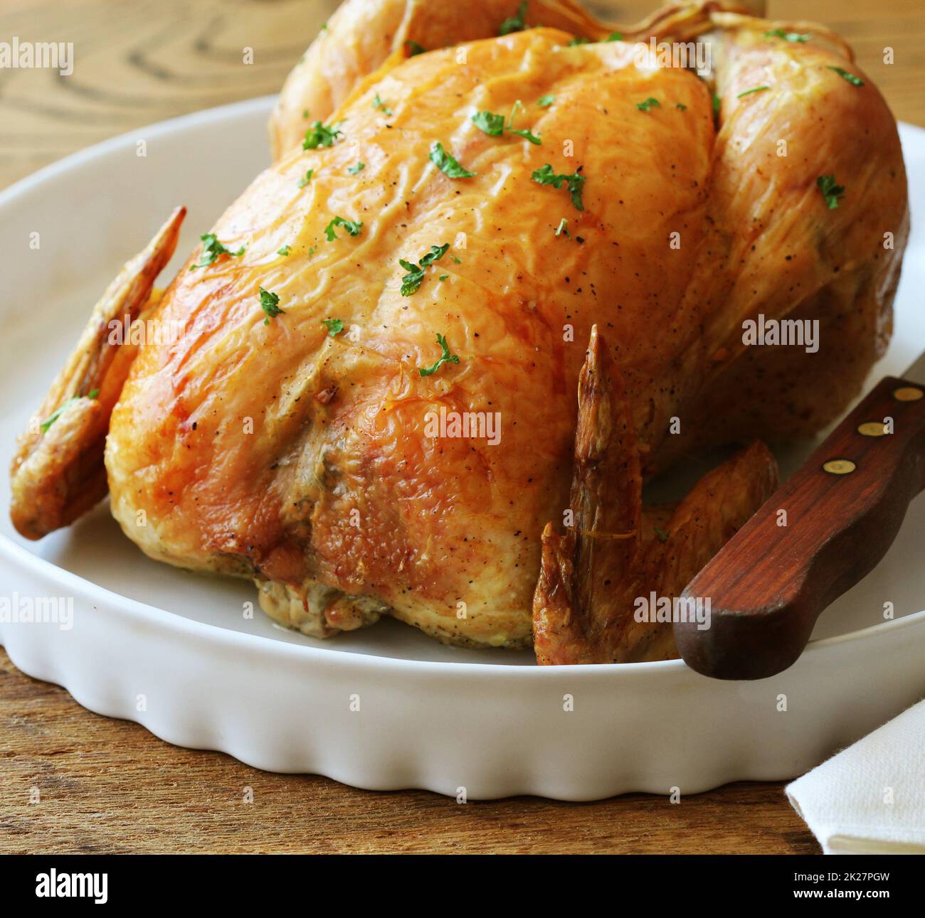 Tutto il tacchino arrosto su piastra bianca. In legno sfondo rustico Foto Stock