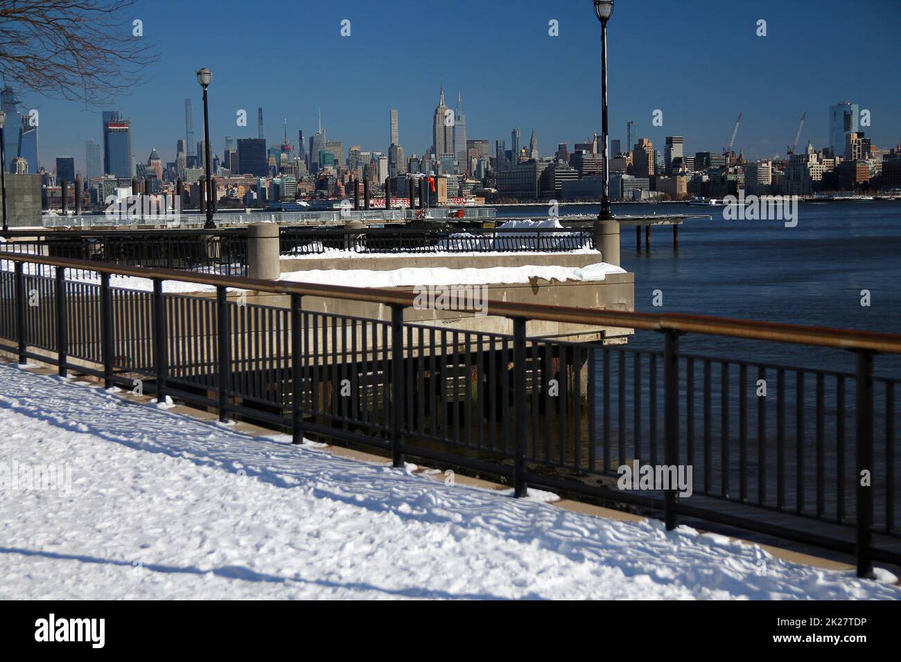 Midtown Manhattan e l'Empire state Building con la neve dal fiume Hudson passerella Foto Stock