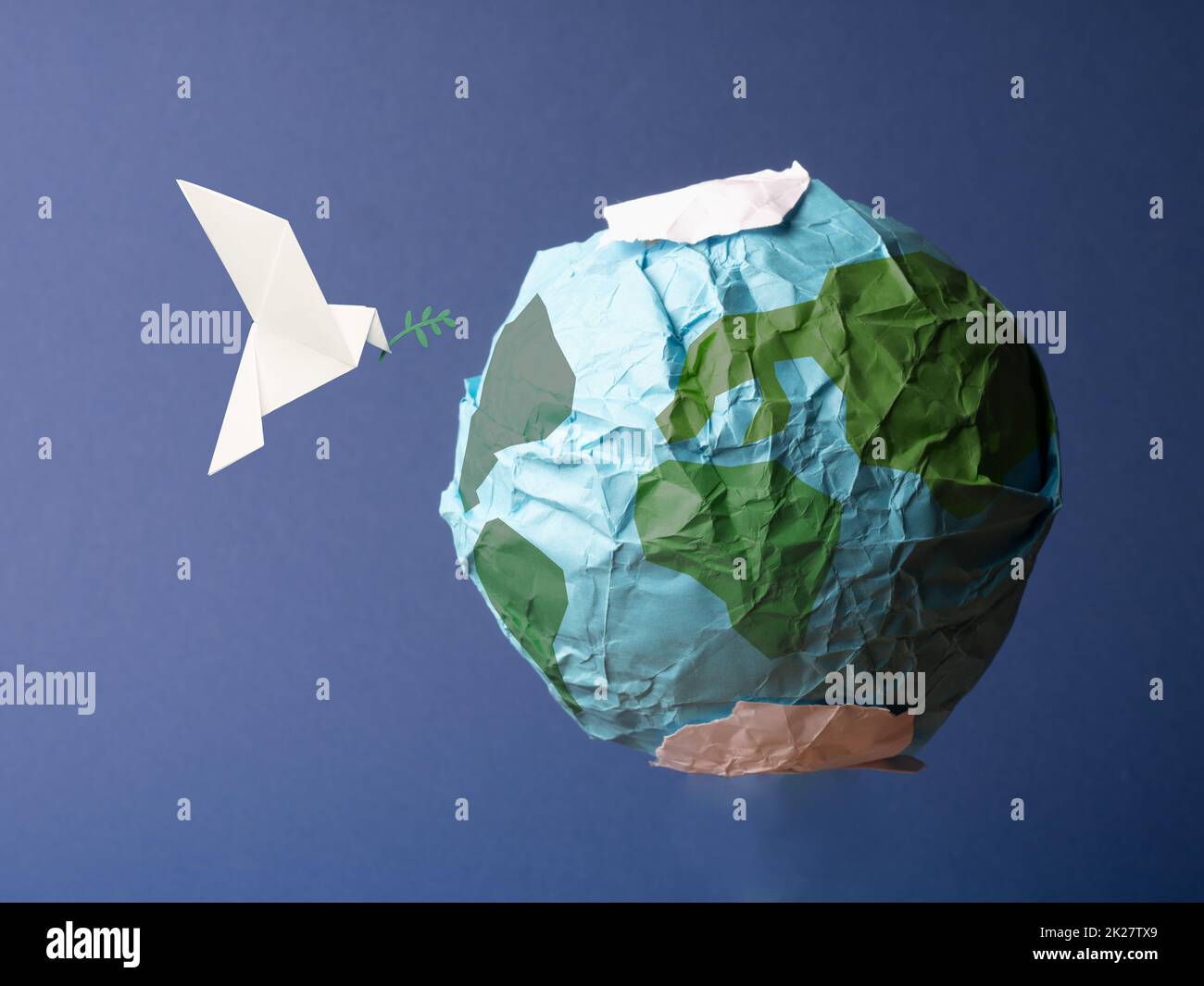 Globo astratto fatto di carta stropicciata con colomba di pace origami Foto Stock