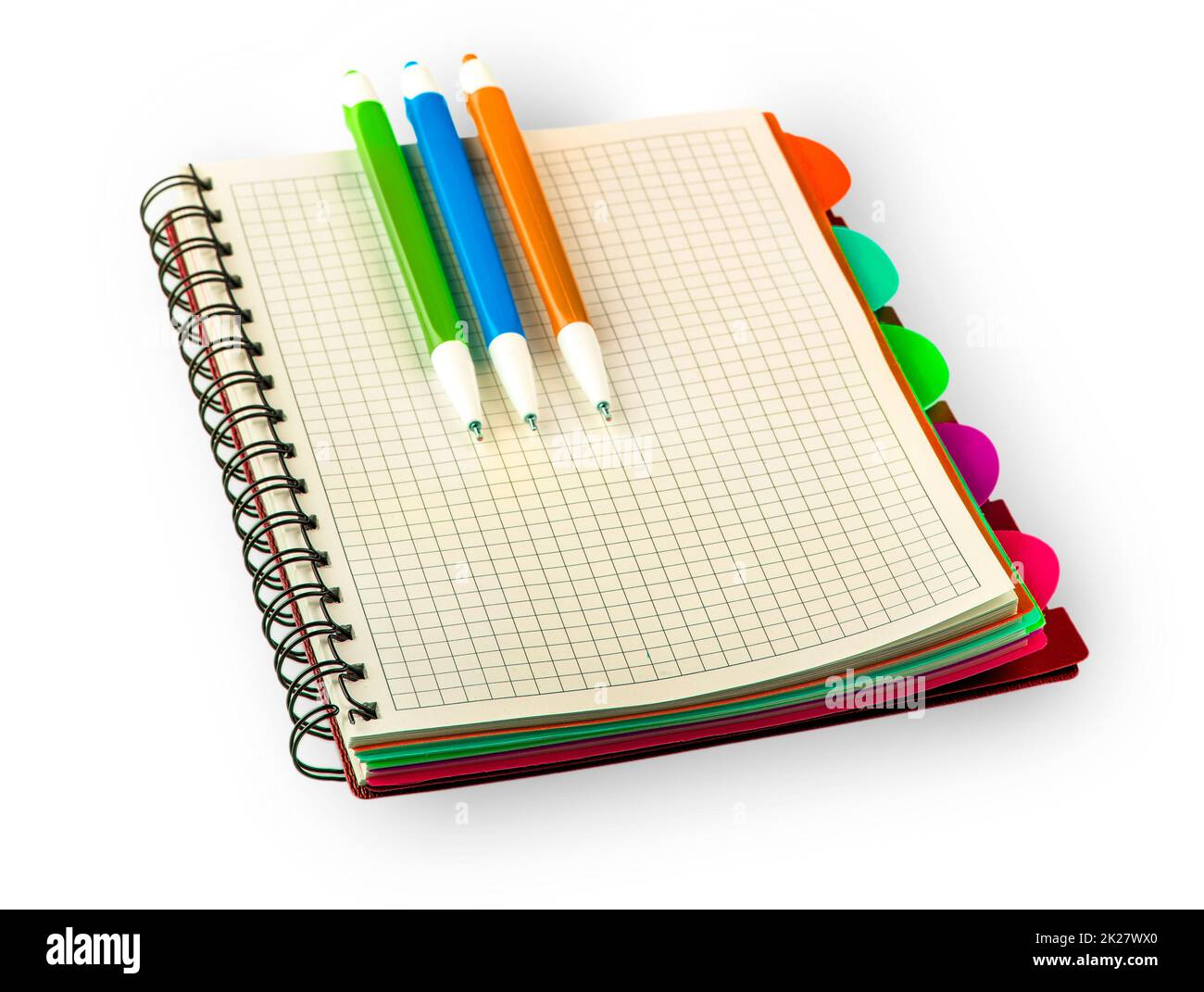 Notebook Diario rosso e penne colorate isolate su sfondo bianco. Foto Stock