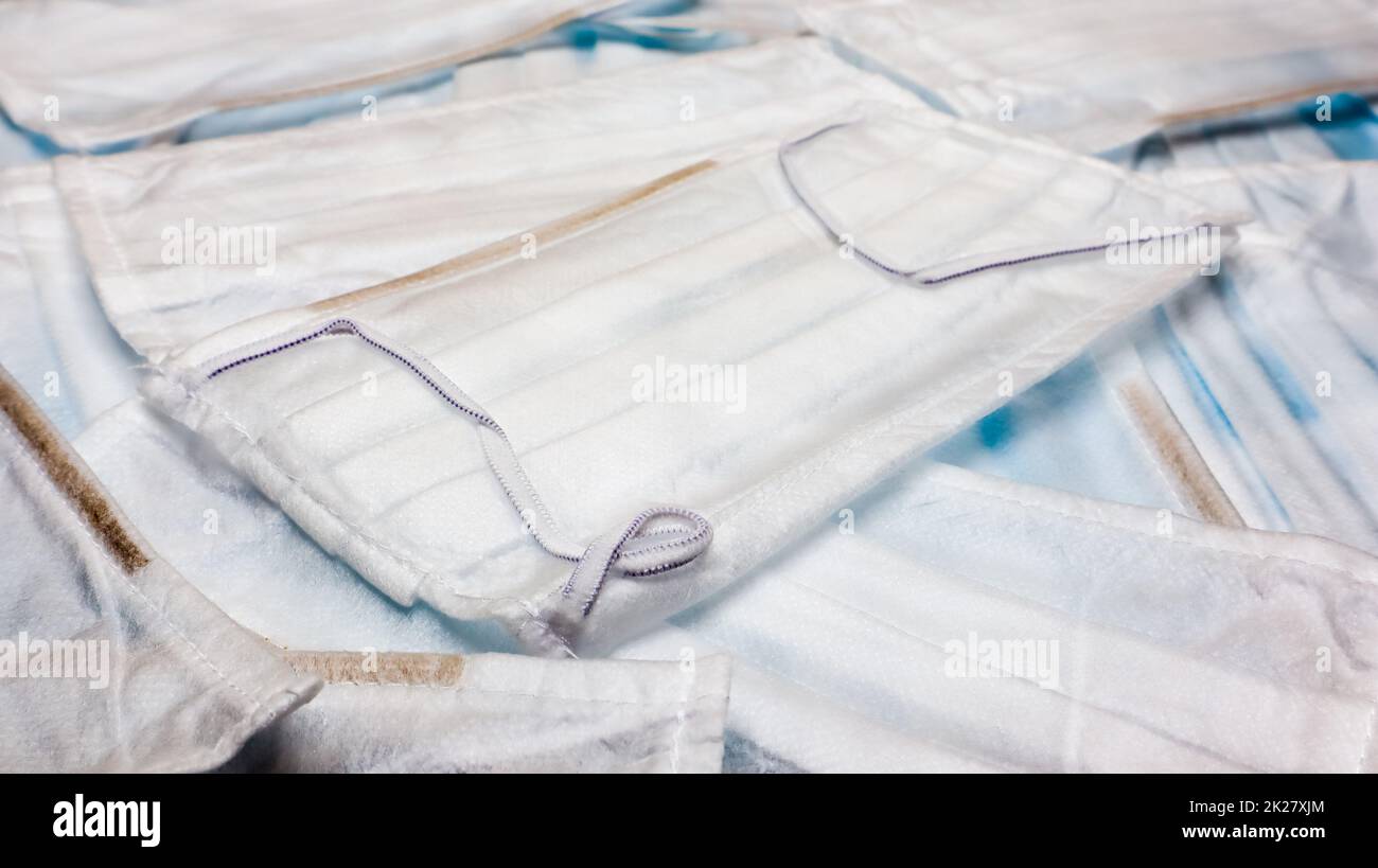 Protezione contro il coronavirus. Maschere antivirali di protezione medica con anelli auricolari. Sfondo della maschera chirurgica. Sindrome respiratoria, malattia del coronavirus COVID-19. Molte mascherine mediche piegate. Foto Stock