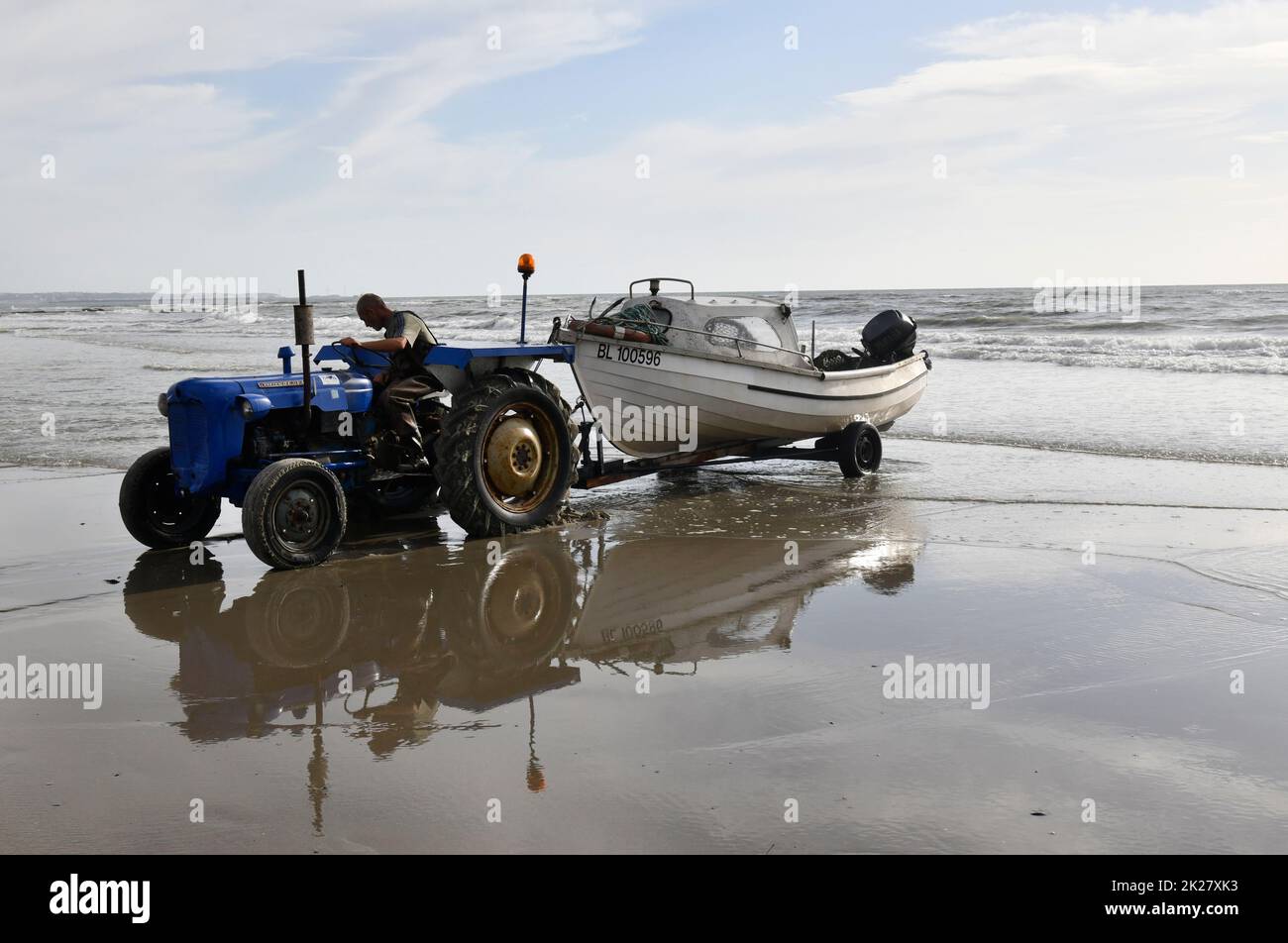 Ambleteuse spiaggia Cote d'Opale Francia settentrionale pescatore traino barca al mare con trattore. Foto Stock