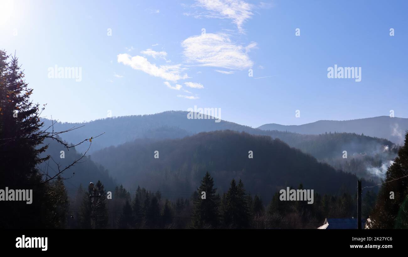 Pioggia autunnale e nebbia sulle colline di montagna. Misty autunno foresta coperta di basse nuvole. Ucraina. Alberi di abete rosso foresta sulle colline di montagne che si attacca attraverso la nebbia mattutina sui paesaggi autunnali. Foto Stock