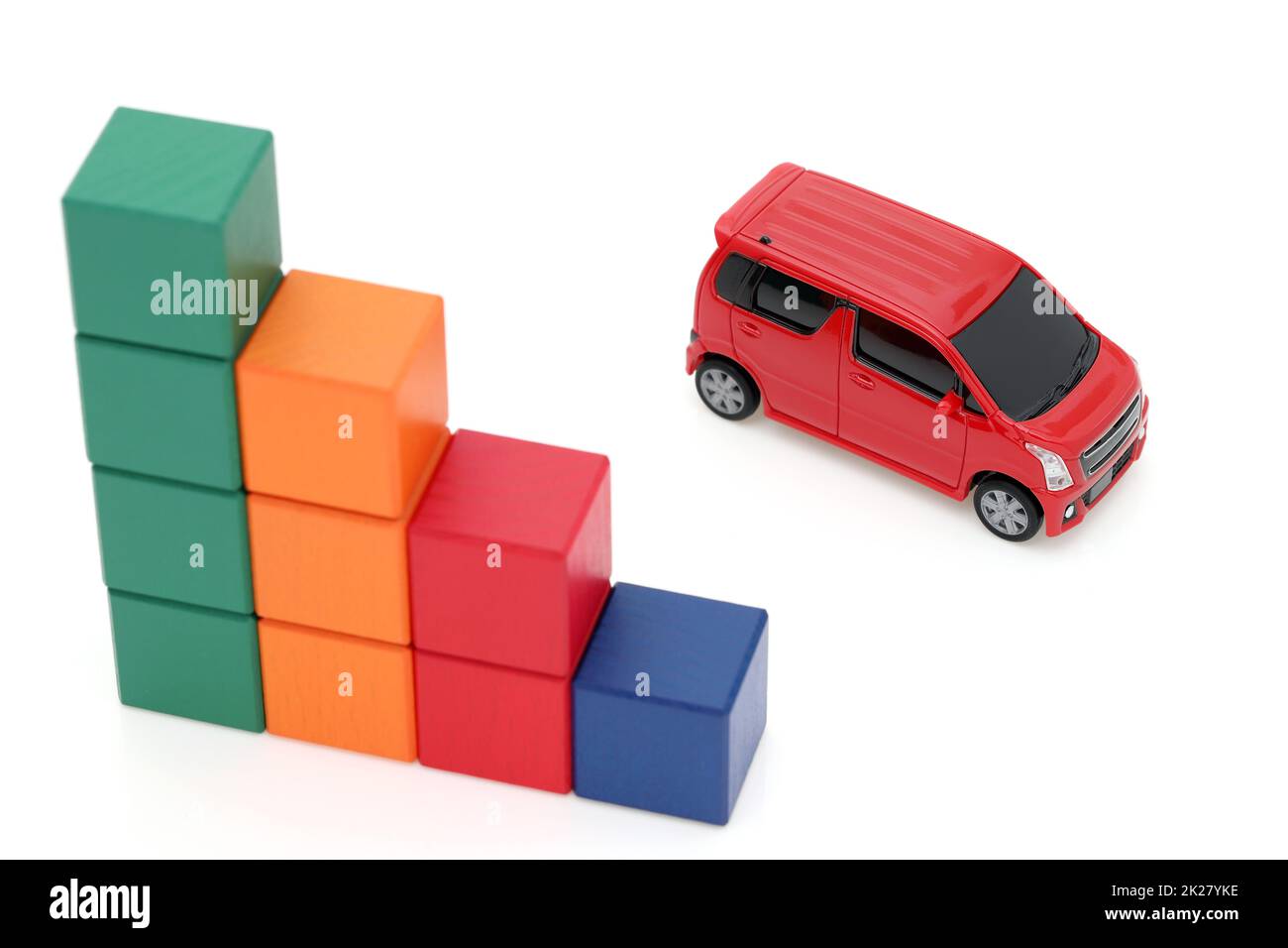 Piccola auto giocattolo e blocchi di legno colorati su sfondo bianco Foto Stock