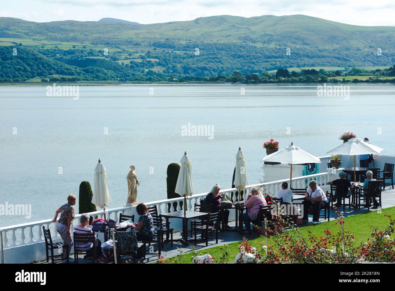 Portmerion - Galles - Settembre 14 2022 : i turisti si rilassano su una terrazza soleggiata sul fiume. Bella, pittoresca vista estiva in una giornata di sole. Foto Stock