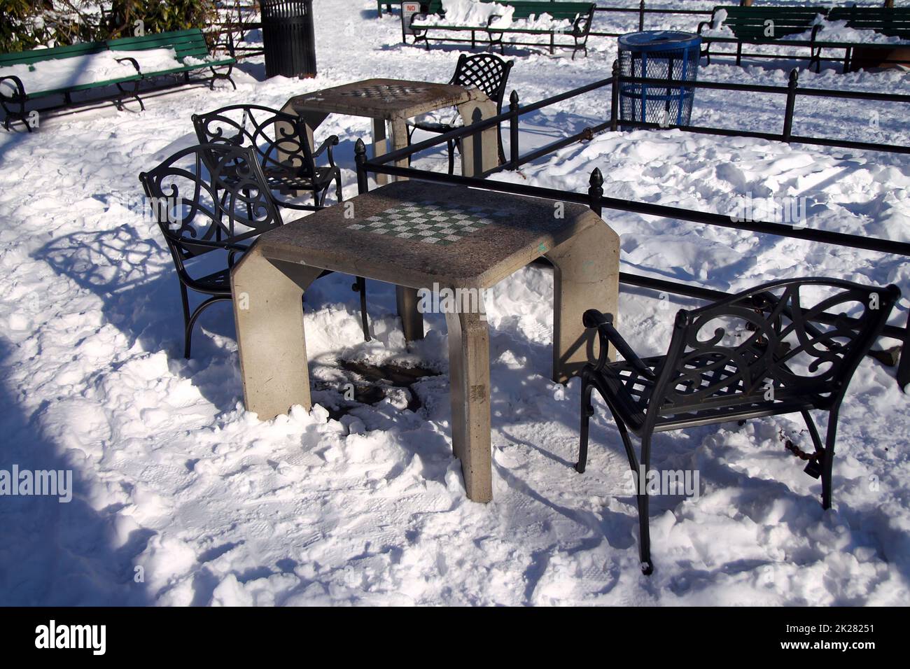 Un tavolo di scacchiera in cemento con una sedia in ferro pesante Foto Stock
