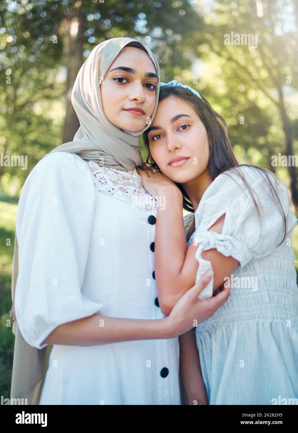 Donna musulmana, amici e fiducia in piedi fuori in un parco e natura con sostegno, amore e un buon rapporto. Ritratto arabo medio-orientale Foto Stock