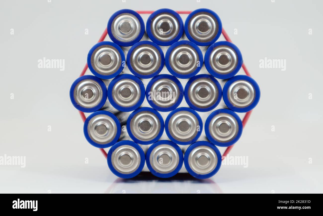 Numerose batterie alcaline AA e AAA su sfondo bianco. Concetto di riciclaggio ecologico. I terminali delle batterie monouso sono vicini e formano uno sfondo bellissimo. Fonte di energia. Foto Stock