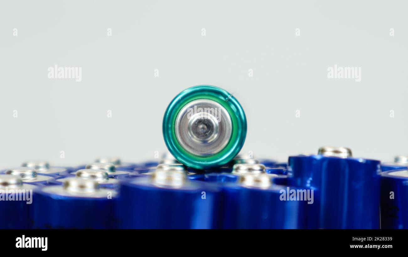 Numerose batterie alcaline AA e AAA su sfondo bianco. Concetto di riciclaggio ecologico. I terminali delle batterie monouso sono vicini e formano uno sfondo bellissimo. Fonte di energia. Foto Stock