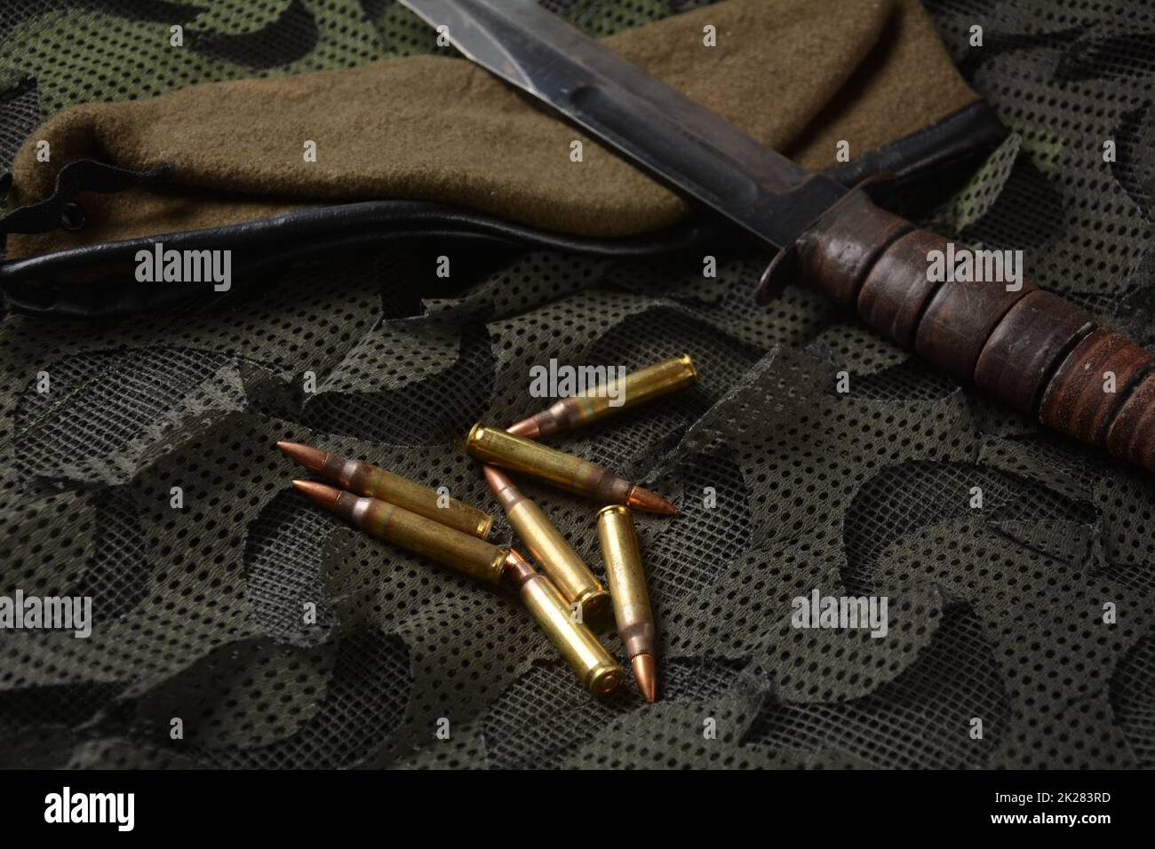 Foto di 5,56mm munizioni, e combattere coltello tattico con berretto militare di oliva Foto Stock