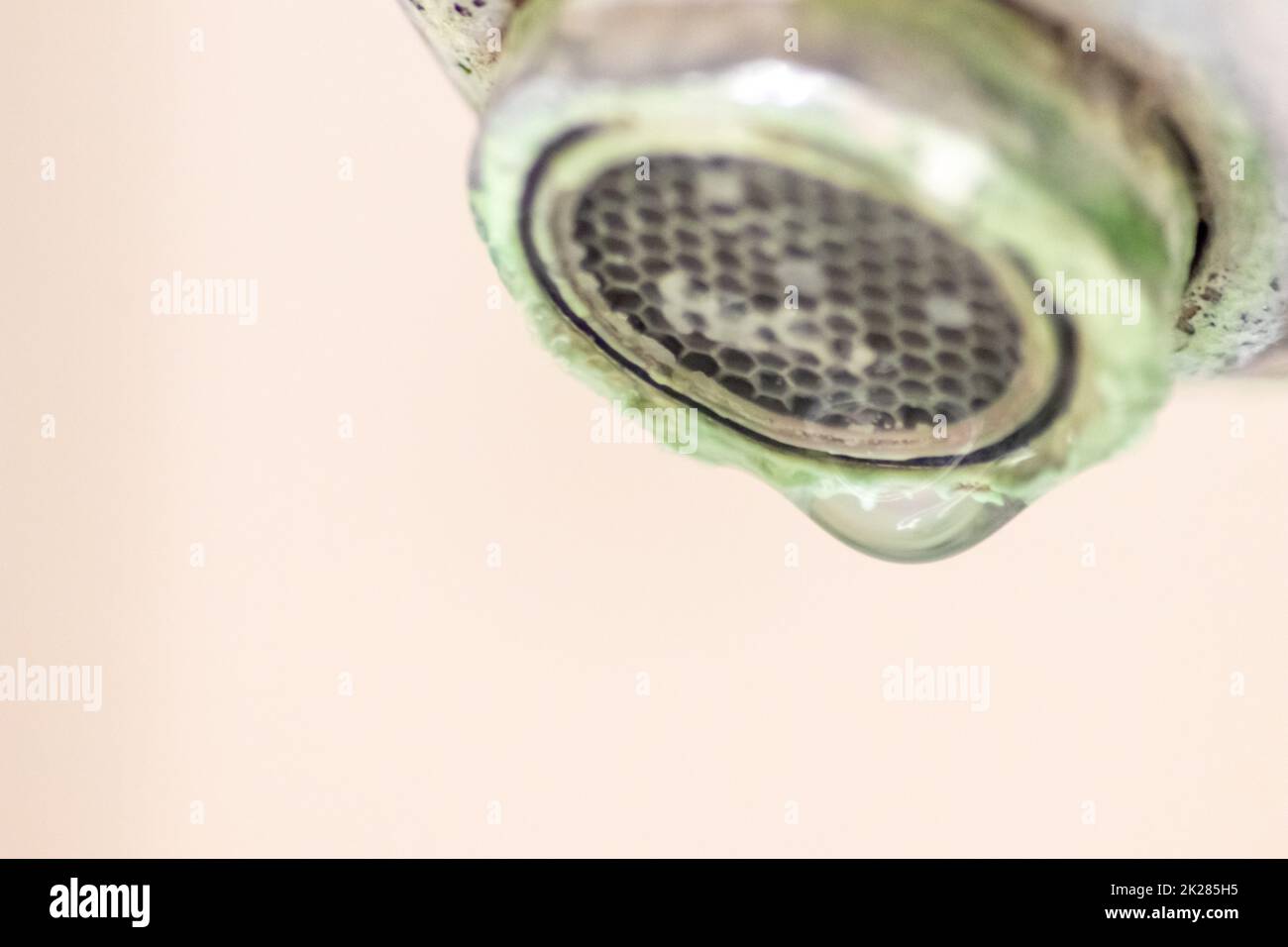 Il vecchio rubinetto graduato come manico calcificato in cromo nel bagno ha bisogno di manutenzione e decalcificazione con detergenti per fermare la perdita e migliorare l'igiene batteri del vecchio manico con la povertà di goccioline Foto Stock