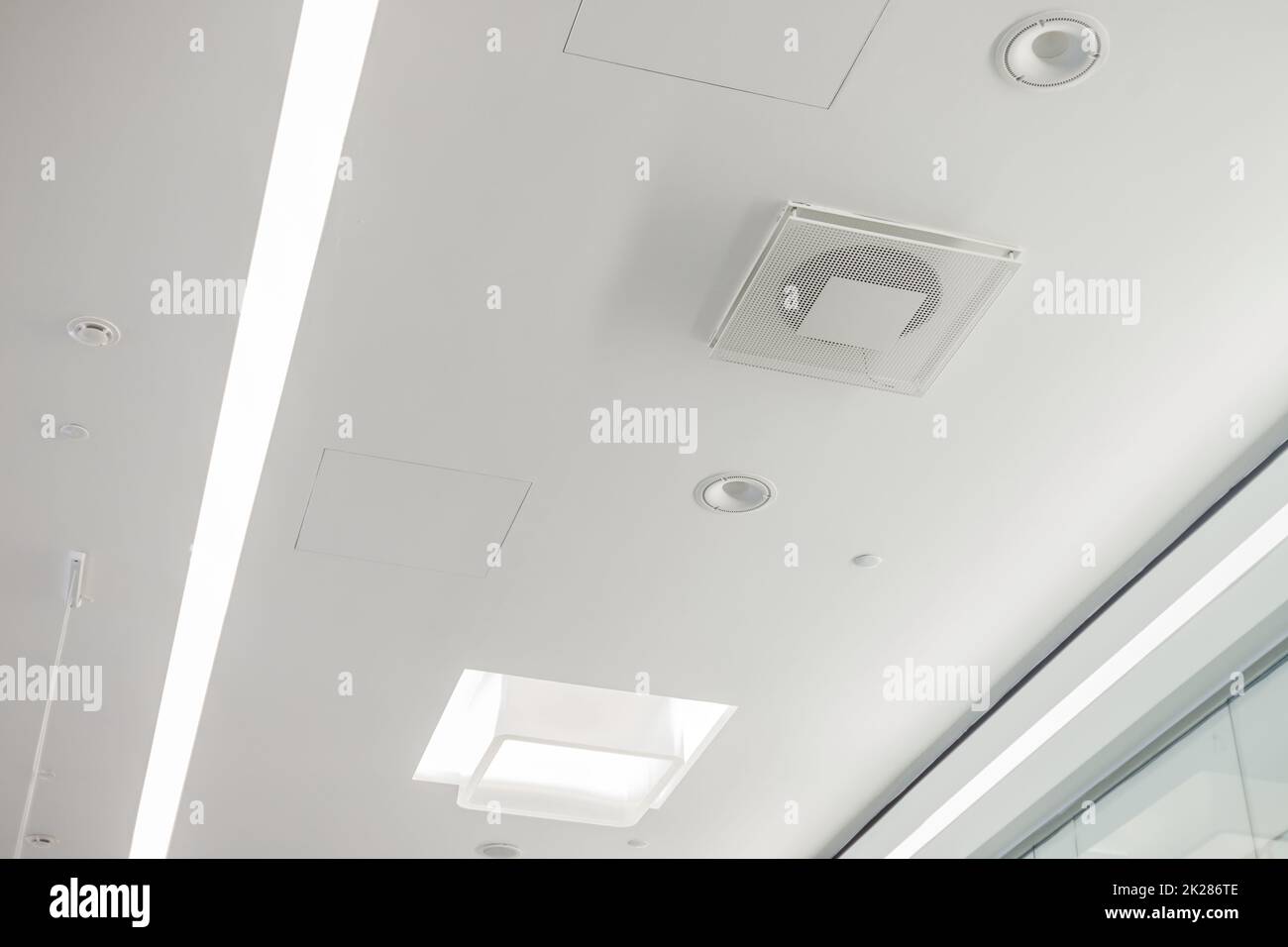Soffitto in cartongesso bianco in edifici amministrativi e pubblici con ventilazione, lampade e altoparlanti Foto Stock