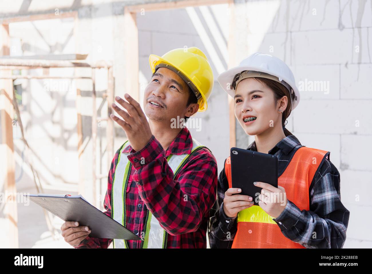 Uomo e donna operaio ingegnere asiatico che lavorano nel cantiere edile Foto Stock