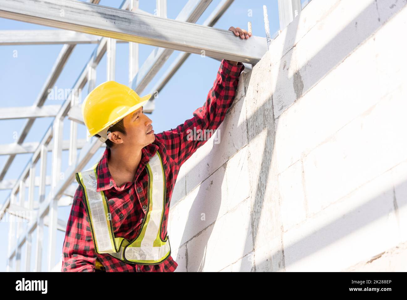 Lavoratore di costruzione o appaltatore che controlla telaio di casa Foto Stock