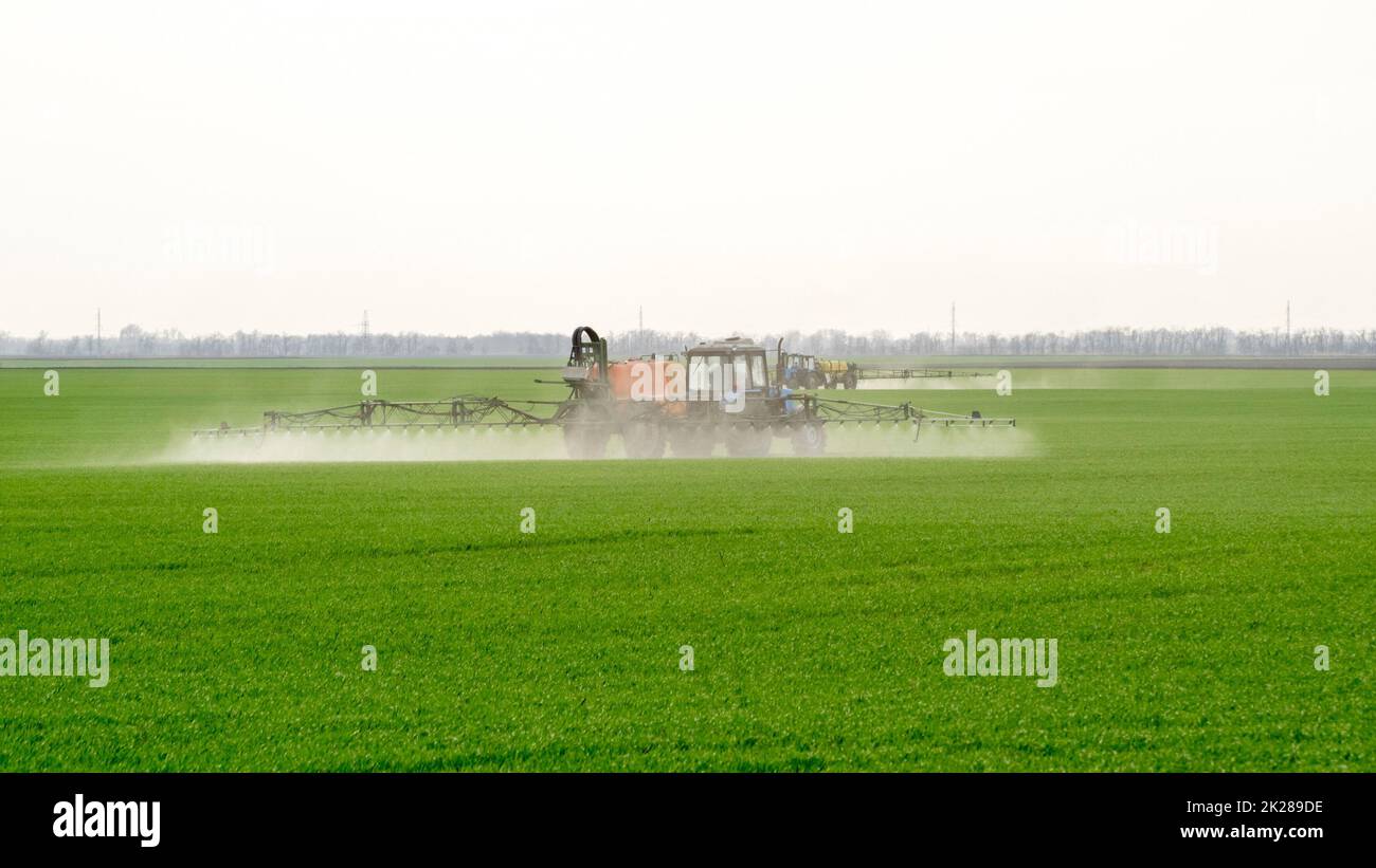 Trattore con dispositivo di spruzzatura per fertilizzante finemente disperso. Foto Stock