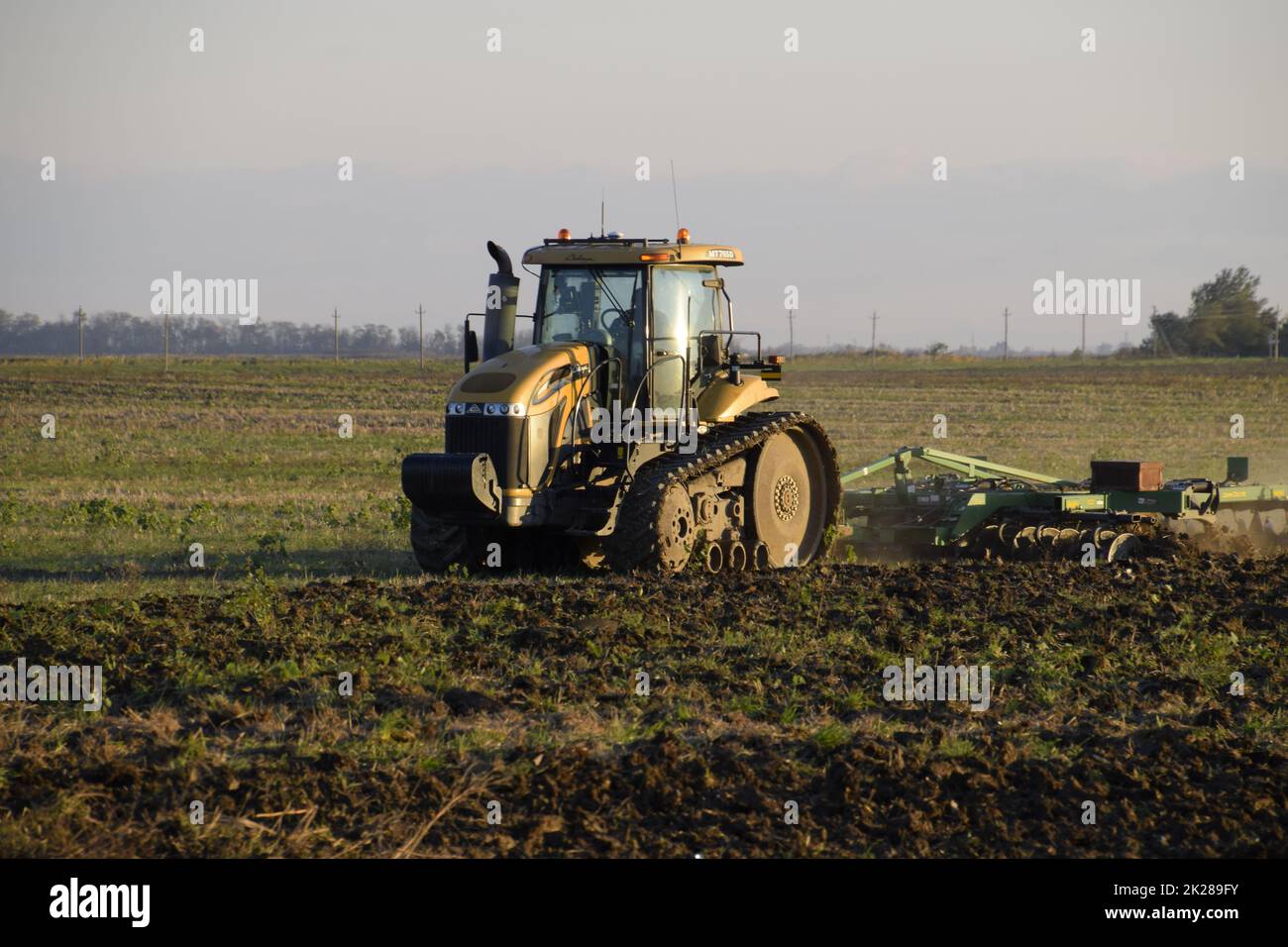 Il trattore aratura arare il campo. Coltivando il suolo nella caduta dopo raccolto. La fine della stagione Foto Stock