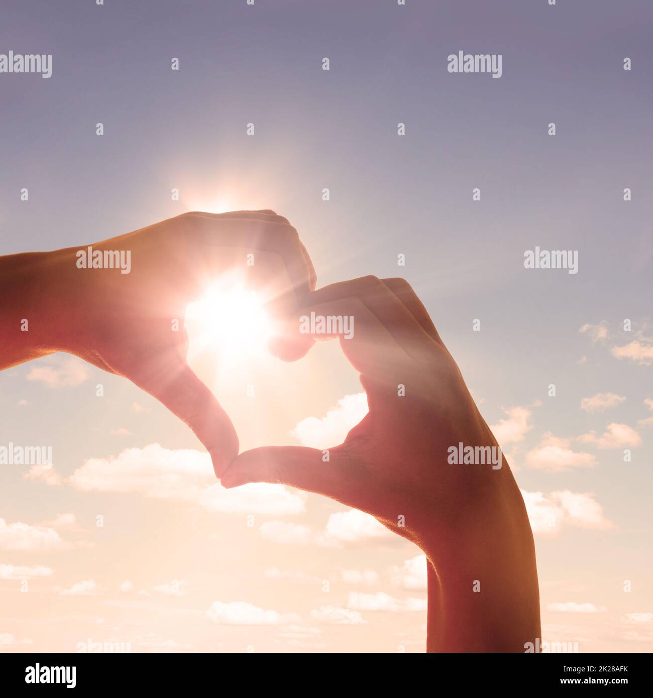 Cuore a forma di mano contro il tramonto. Concetto di giorno di San Valentino Foto Stock