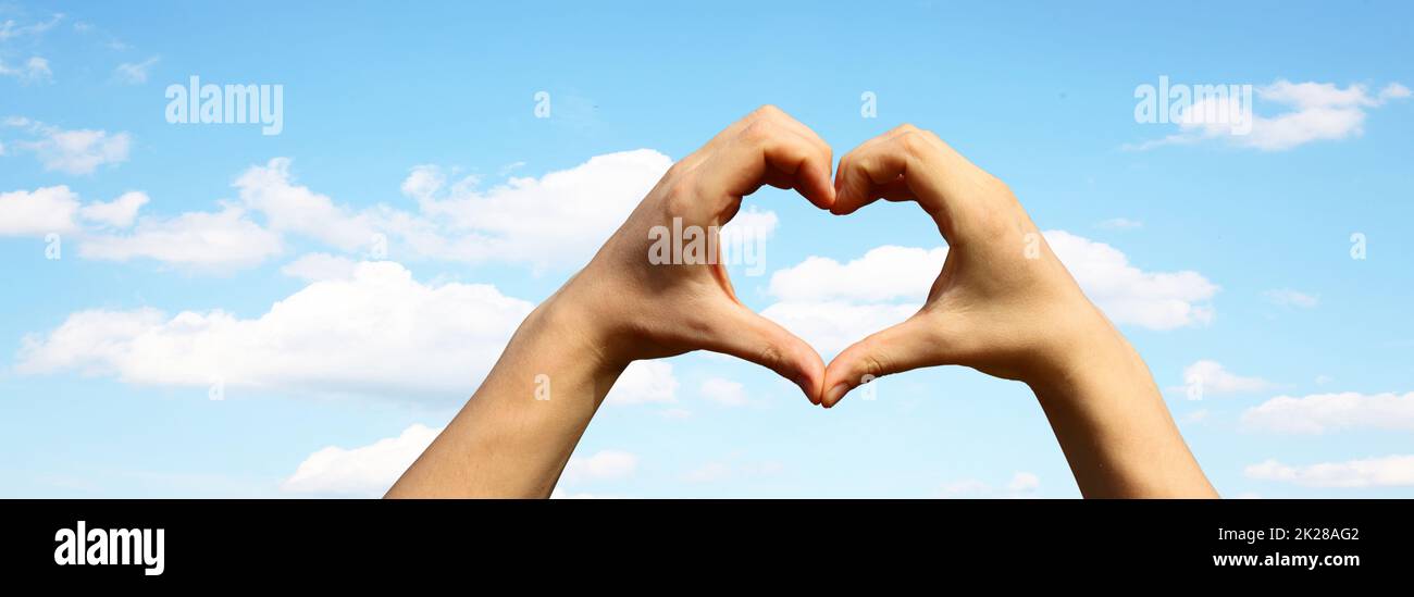 Cuore a forma di mano contro il tramonto. Concetto di giorno di San Valentino Foto Stock