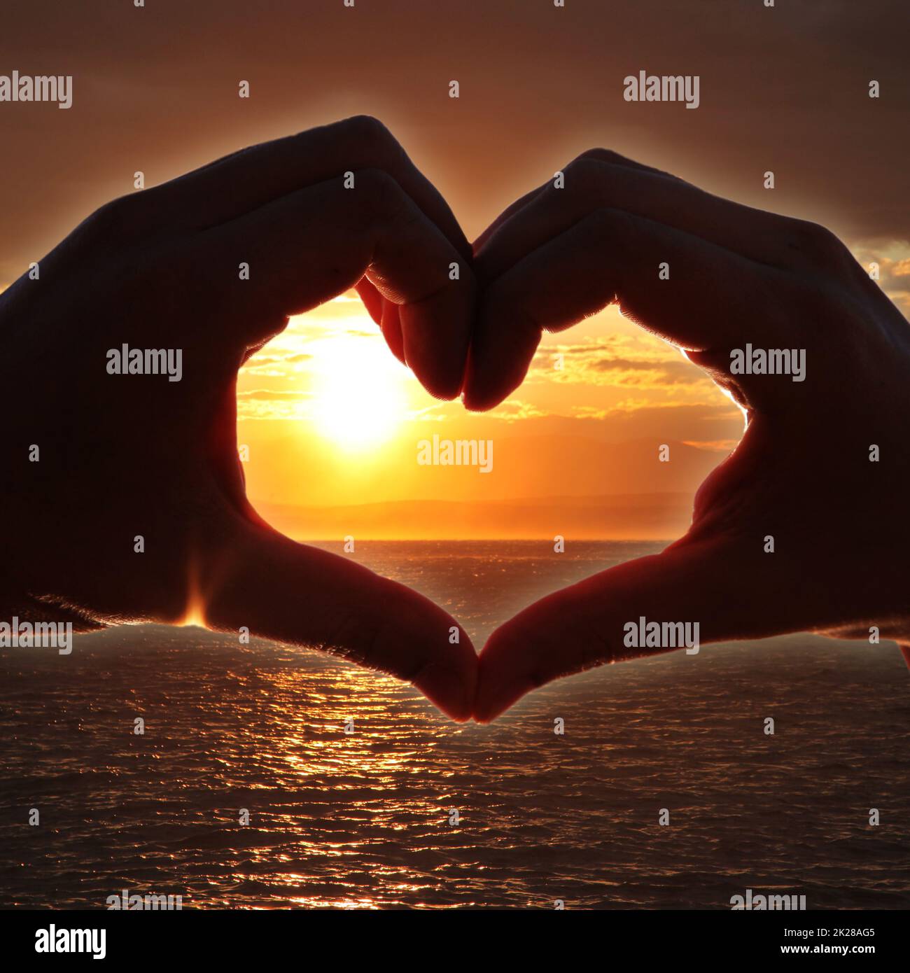 Cuore a forma di mano contro il tramonto. Concetto di giorno di San Valentino Foto Stock