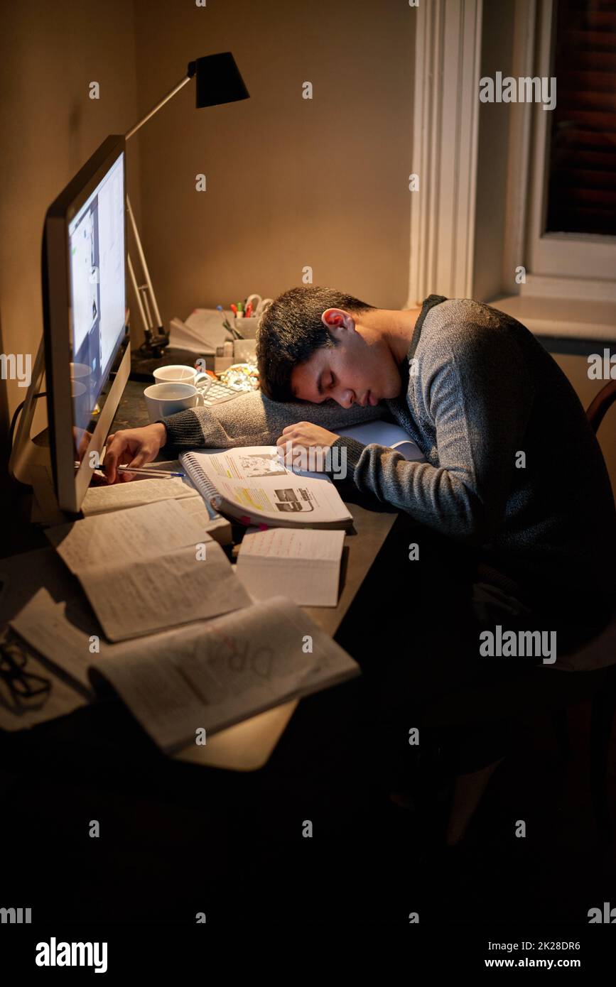 Esausto prima del suo esame. Un giovane studente che studia fino a tarda notte. Foto Stock