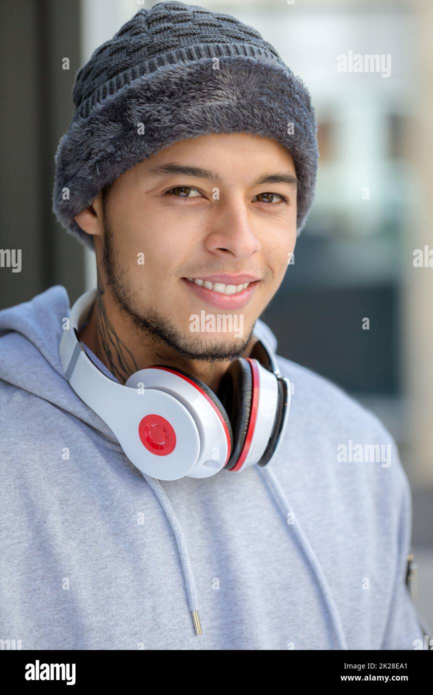 Ritratto di un giovane uomo latino allenamento sportivo con cuffie inverno freddo runner Foto Stock