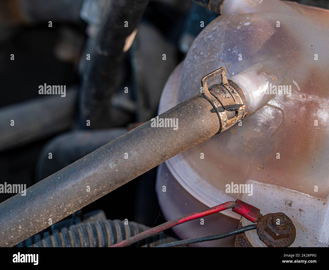 Morsetto in metallo per il fissaggio del tubo flessibile in gomma del serbatoio in plastica del liquido di raffreddamento dell'auto. Foto Stock