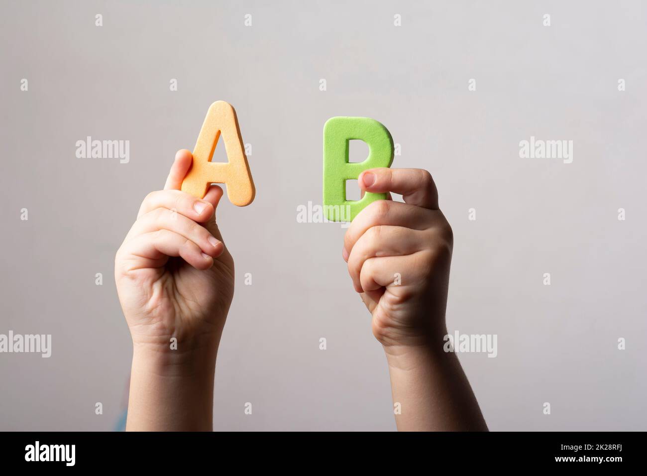 Mani che tengono due lettere AB spugnose Foto Stock